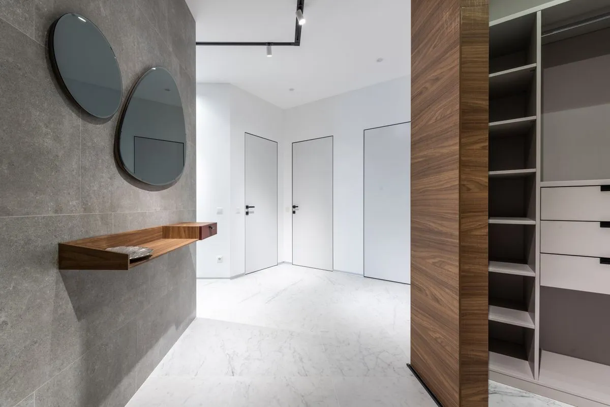 Entrée contemporaine avec portes affleurantes blanches et rangement ouvert à étagères et tiroirs habillé de bois